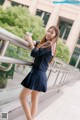 A woman in a school uniform holding a drink.