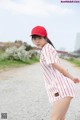 A woman in a red and white striped dress and a red hat.