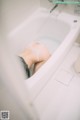 A woman laying in a bathtub in a bathroom.