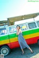 A woman standing in front of a colorful van.