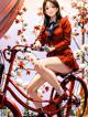 A woman in a red dress sitting on a red bike.