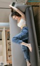 A woman laying on top of a couch next to a table.